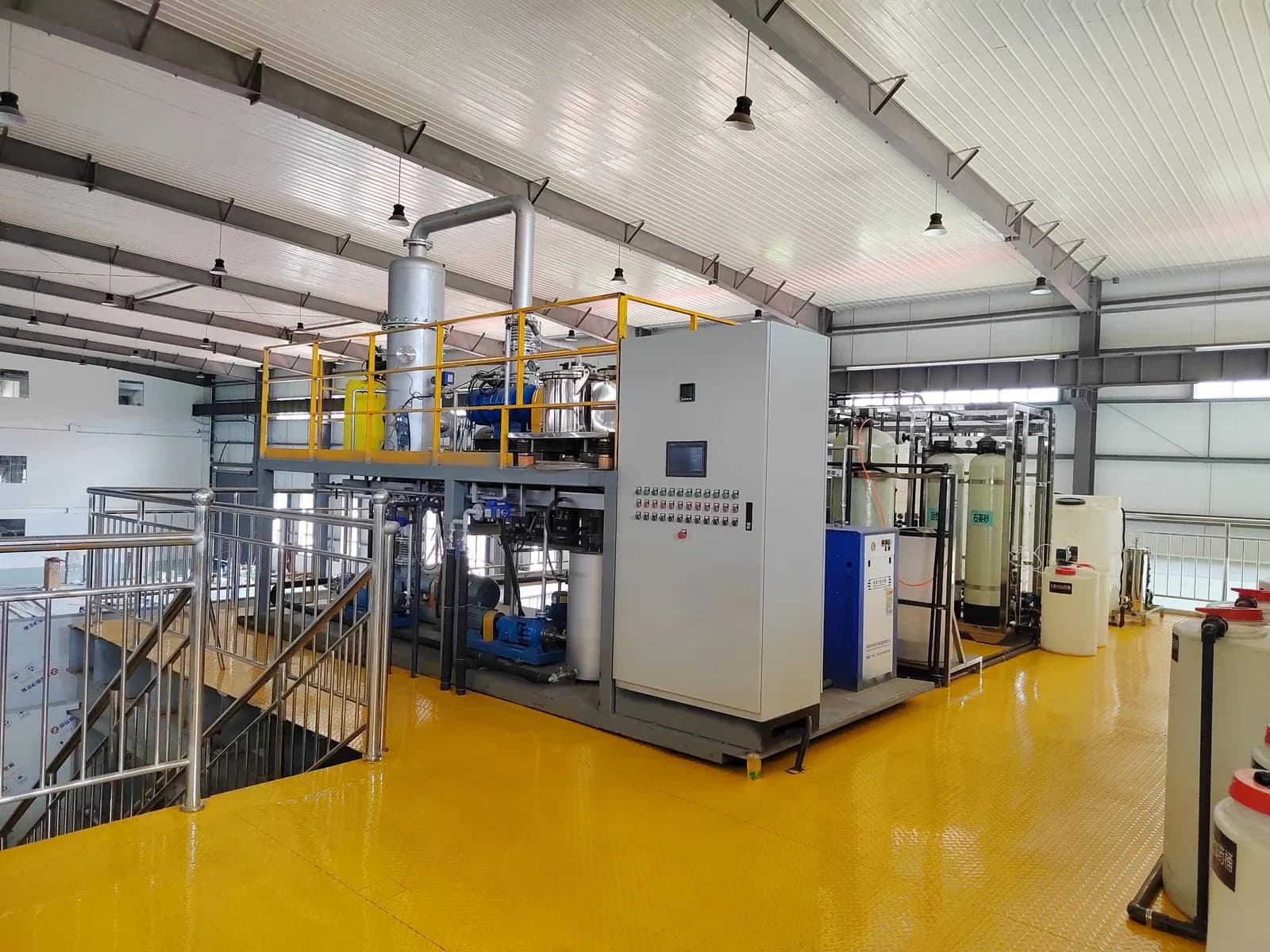Industrial water treatment equipment with a control cabinet and elevated access platform